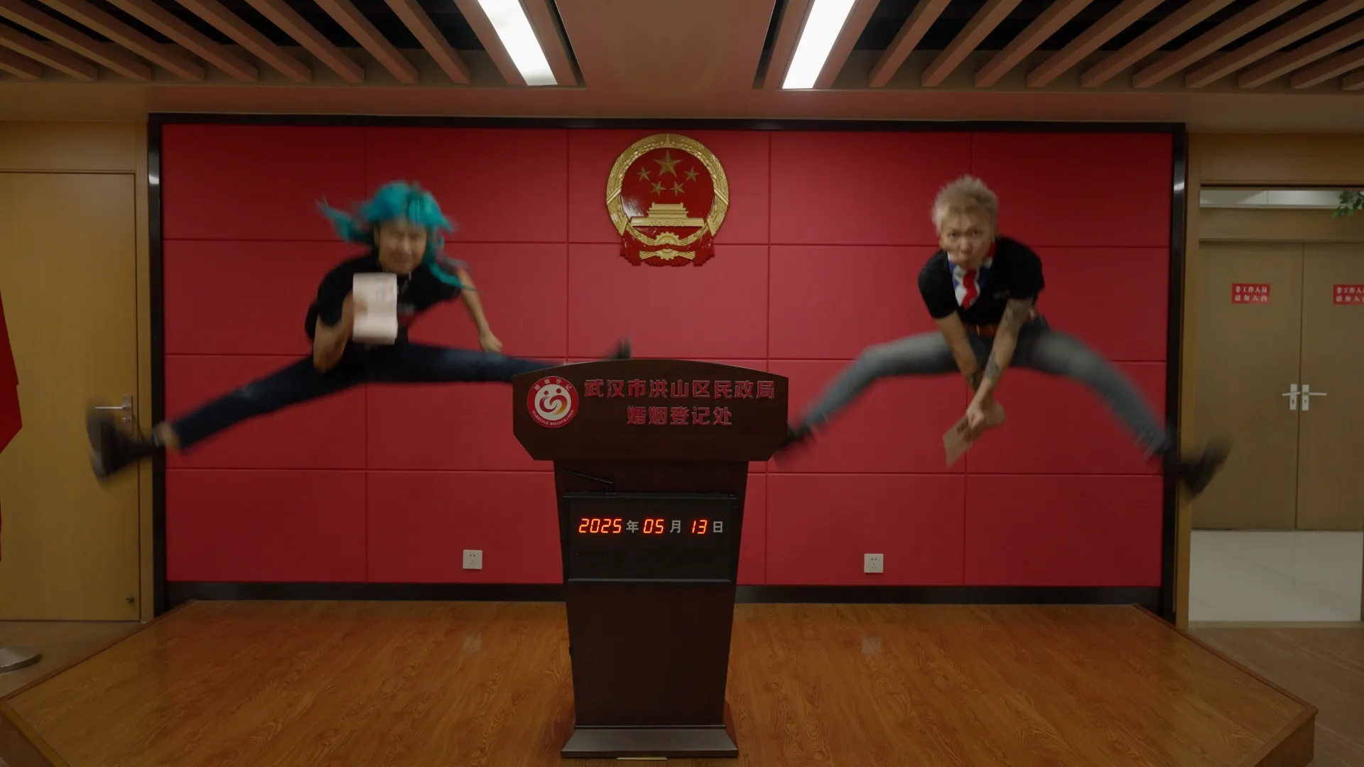 The two protagonists jump in front of the marriage registration desk in a frame from the documentary
