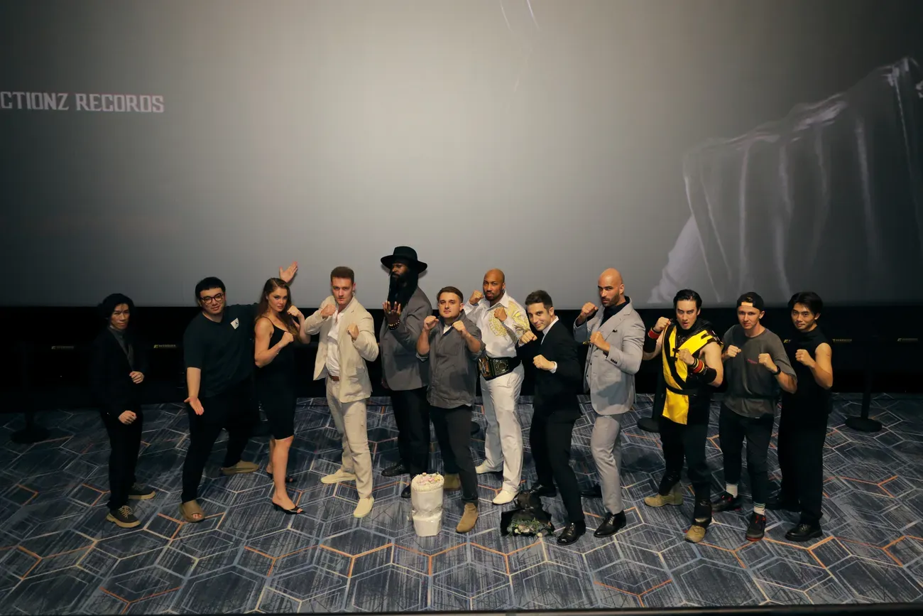 The cast in fighting stances on stage